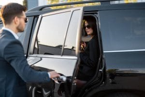 A man and woman are entering a black SUV, likely for a limo rental near Newark, NJ.