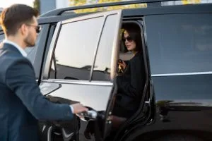 A man and woman are entering a black SUV, likely for a limo rental near Newark, NJ.