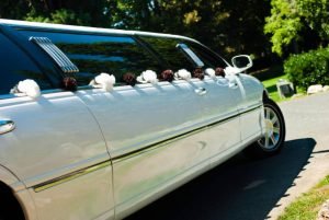 A decorated limousine with flowers on the back, promoting Anniversary Limo Rental Services.
