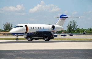A stylish white and blue airplane on the tarmac, showcasing luxury airport transportation options for travelers.