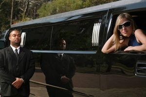 A man and woman stand beside a limousine, dressed for prom night, showcasing the Prom Night Limo Rentals service.