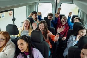 A group of young people enjoying a lively atmosphere while sitting together in a party bus.