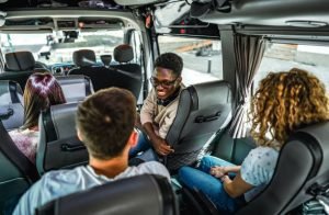 A group of people enjoying a party in the back of a rental bus, smiling and socializing together.