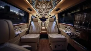  Interior of a luxury Rolls Royce limousine featuring a spacious ceiling and elegant furnishings.