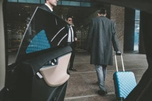 Businessmen in suits and ties exiting a car at Tri State Airport Limo, ready for a professional engagement.